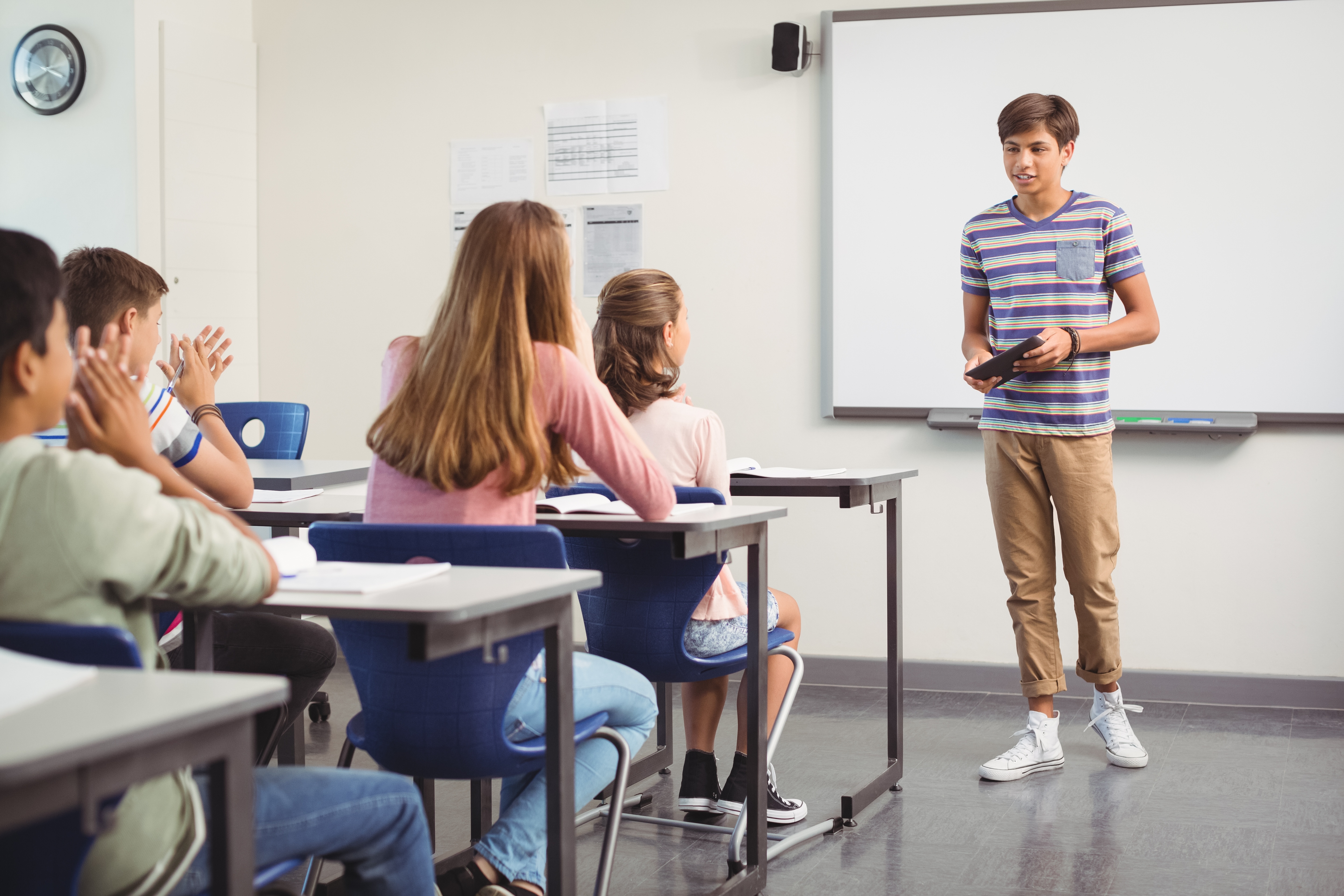 Junge präsentiert vor Klasse und übt Präsentationstechniken