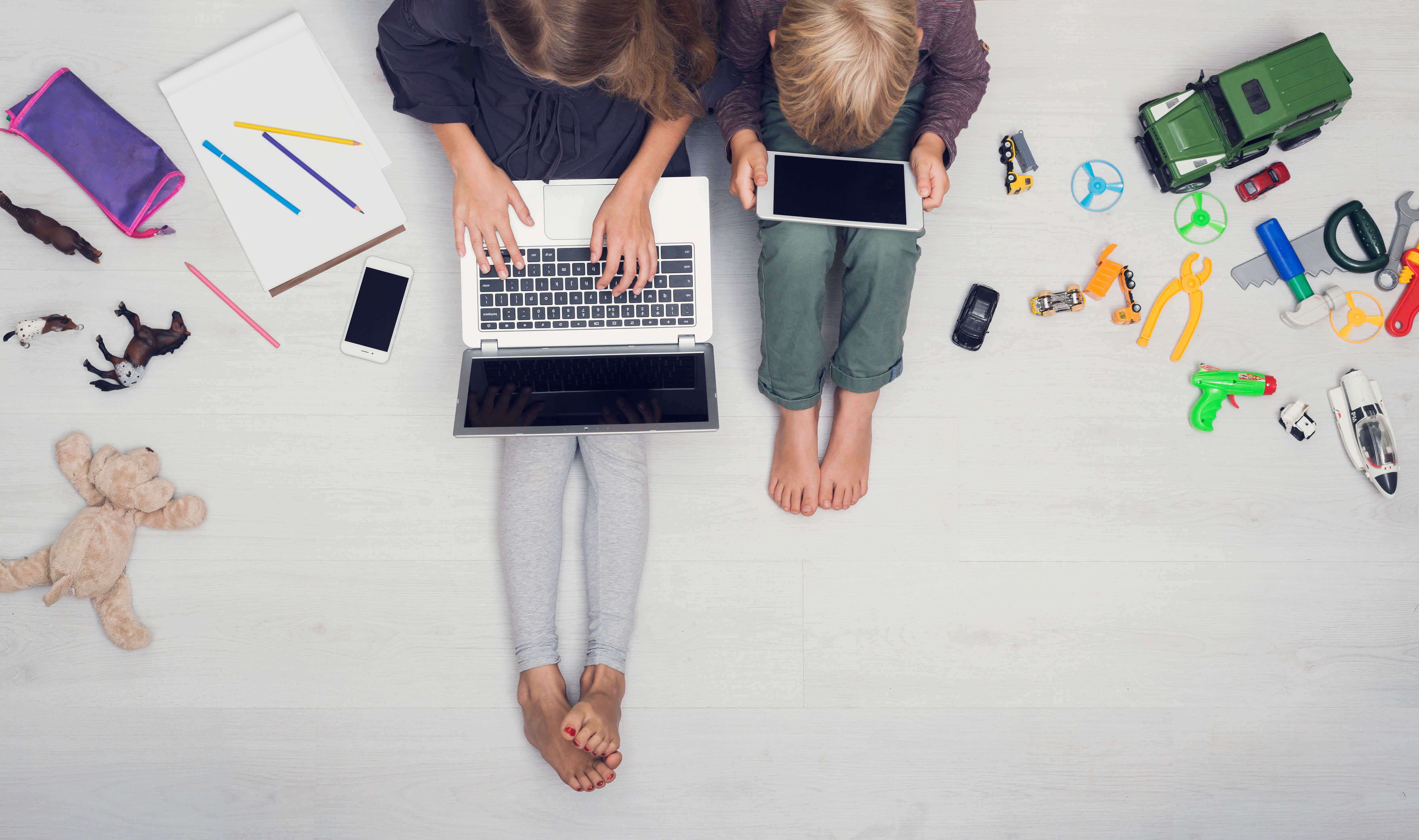 Mädchen und junge vor Laptop und Smartphone