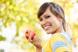 junge Frau hält einen Apfel in der Hand