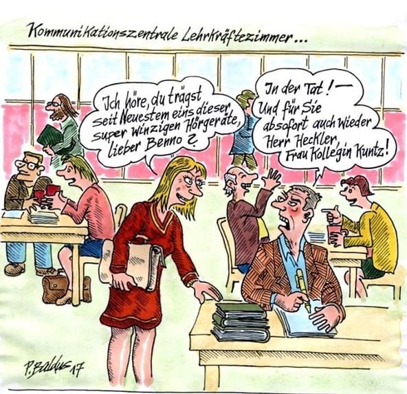 Kommunikationszentrale Lehrerin begrüßt Lehrer mit Hörgerät im Lehrerzimmer