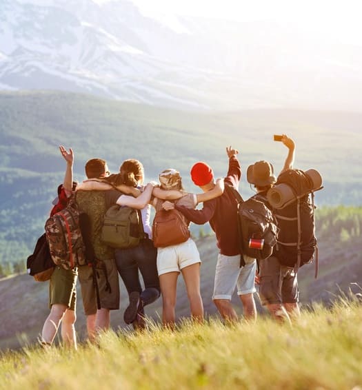 Jugendliche stehen in den Bergen und machen ein Selfie