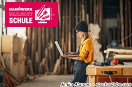 Junge Handwerkerin mit Laptop in einer Werkstatt