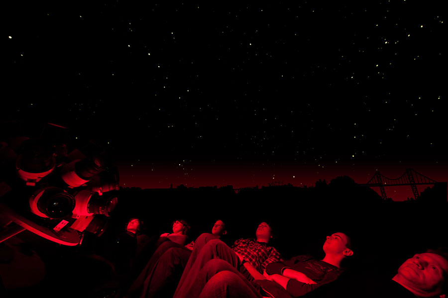Zuschauer und Projektor unter dem Sternenhimmel im selbstgebauten Planetarium