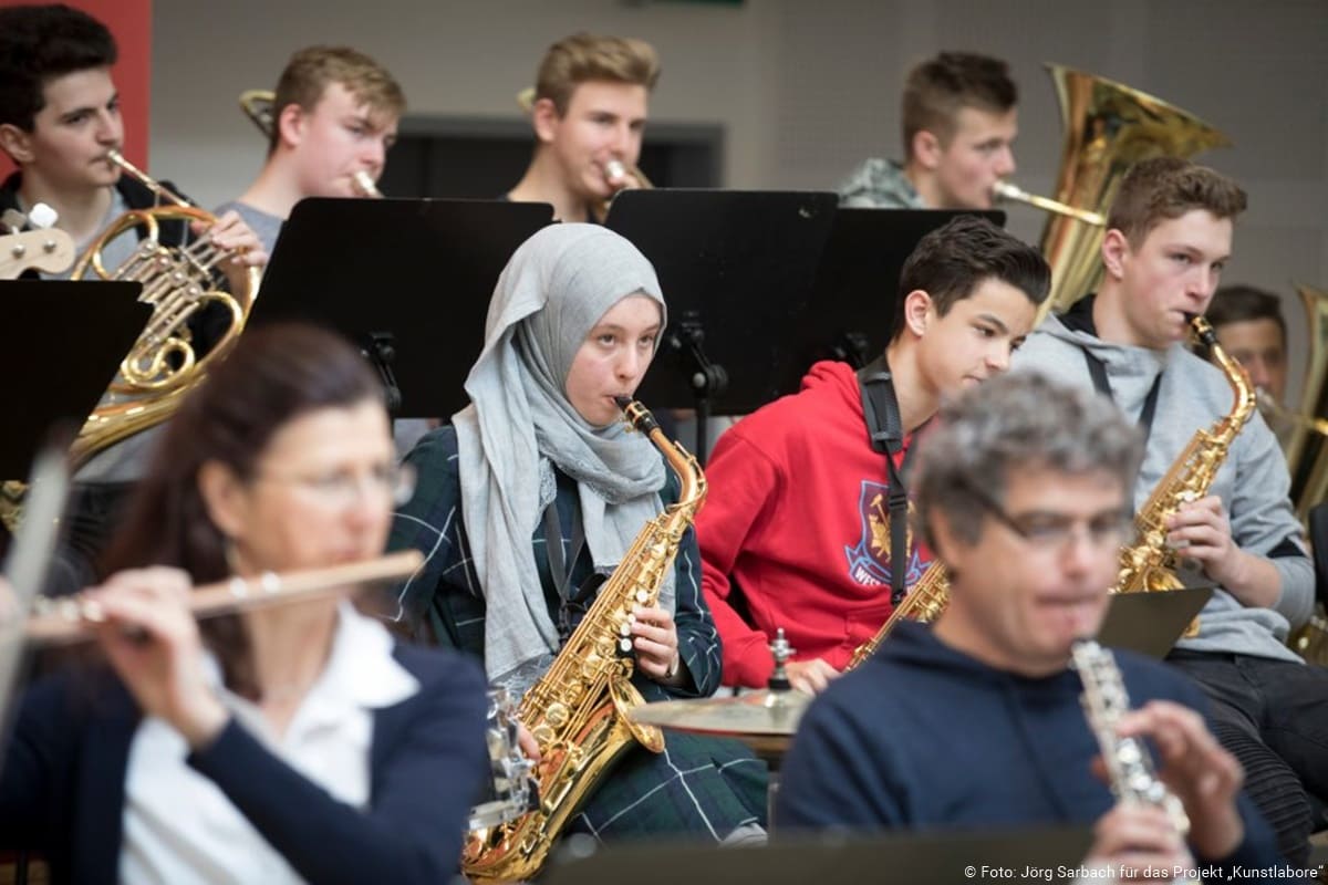 Die Bläserklasse einer Schule musiziert mit einem Orchester