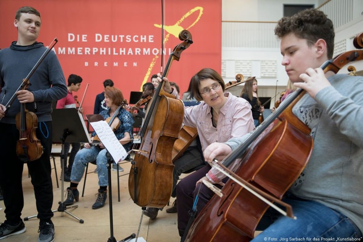 Musiker der deutschen Kammerphilharmonie musizieren mit Schülern