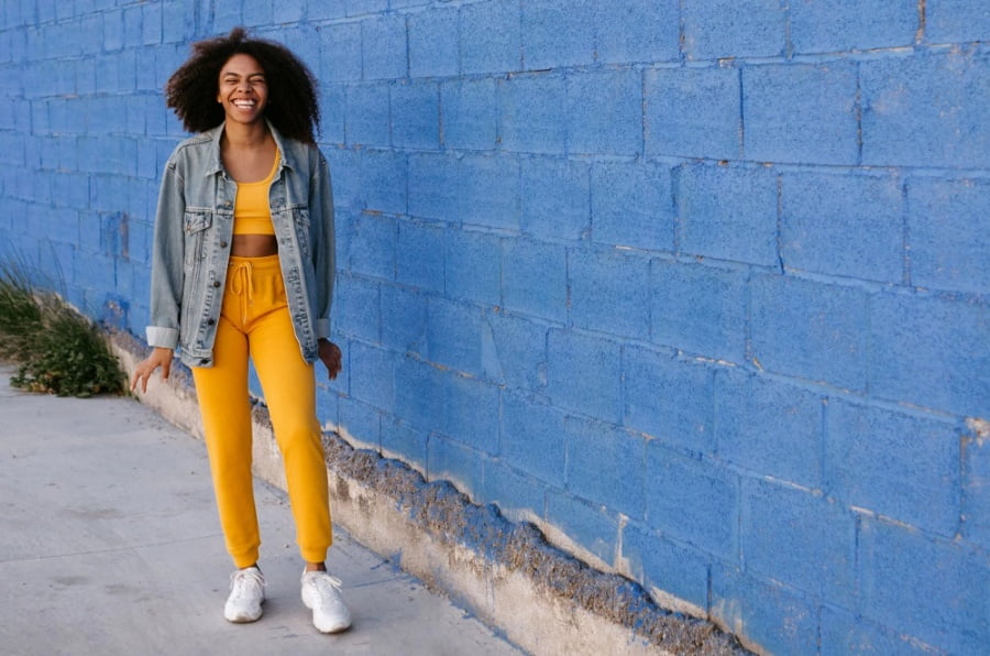 Junge Frau vor einer Steinmauer
