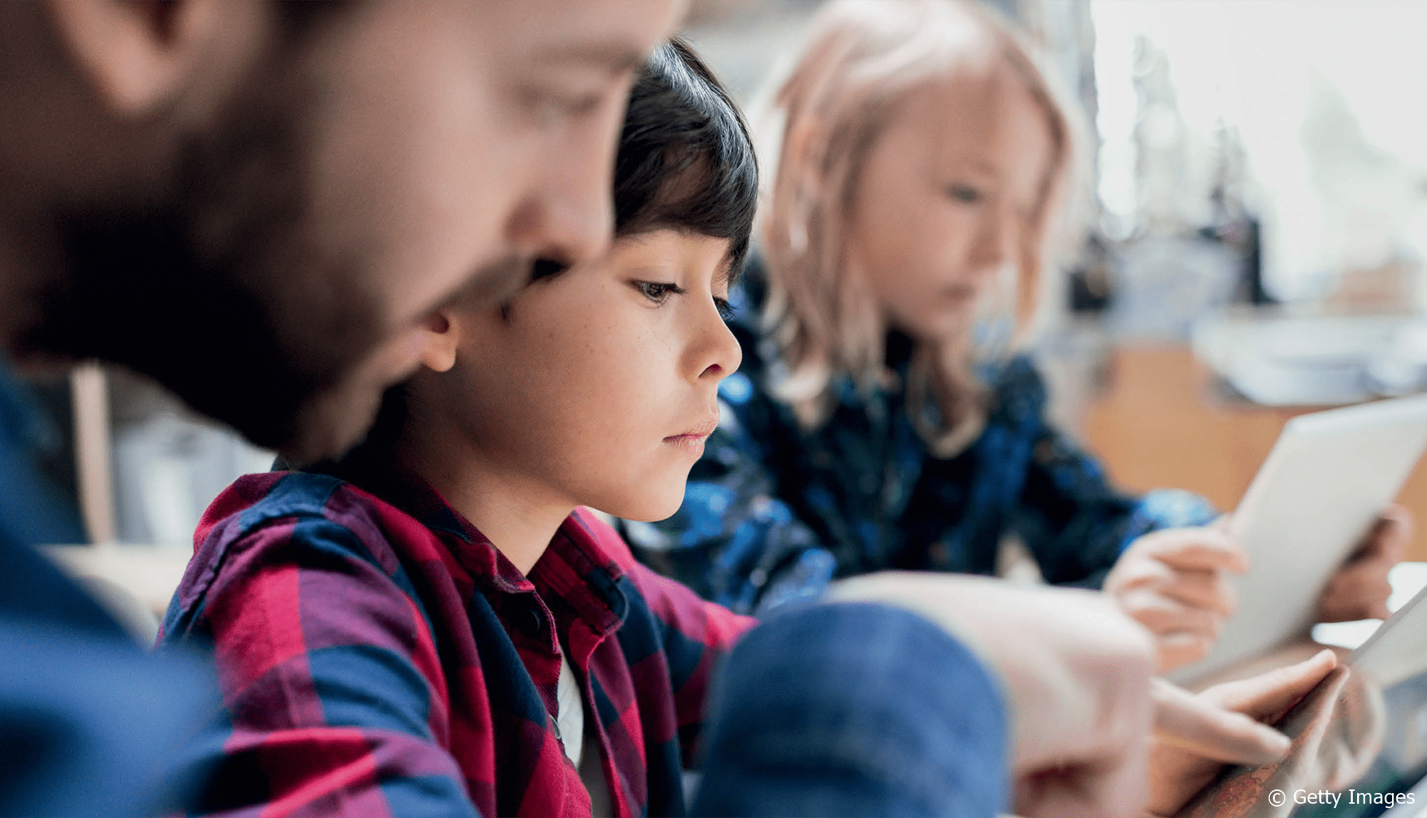 Ein Lehrer zeigt einem Schüler etwas auf einem Tablet