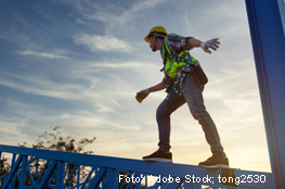 Handwerker balanciert vor Sonnenuntergang