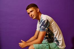 "grips gewinnt" Junge sitzt vor lila Hintergrund