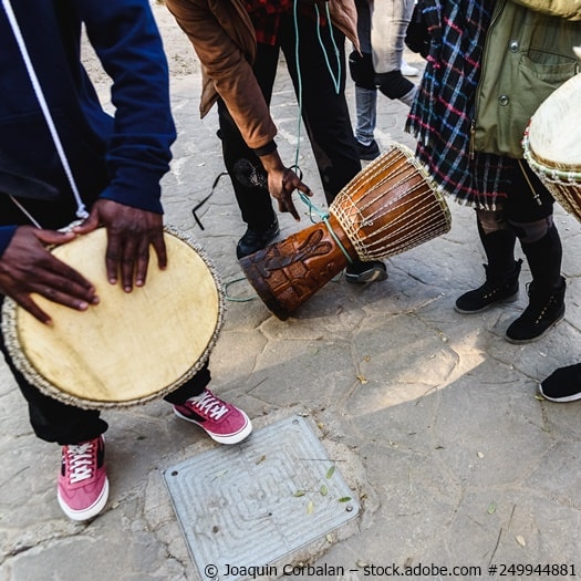 Menschen spielen auf afrikanischen Trommeln