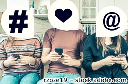 Jugendliche am Smartphone; über ihren Köpfen sind Denkblasen mit den Symbolen Hashtag, Herz und @